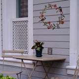 Voeg een vleugje vintage charme toe aan je huis met een mooie metalen deurslinger. De krans toont bladeren, bloemen en vogels